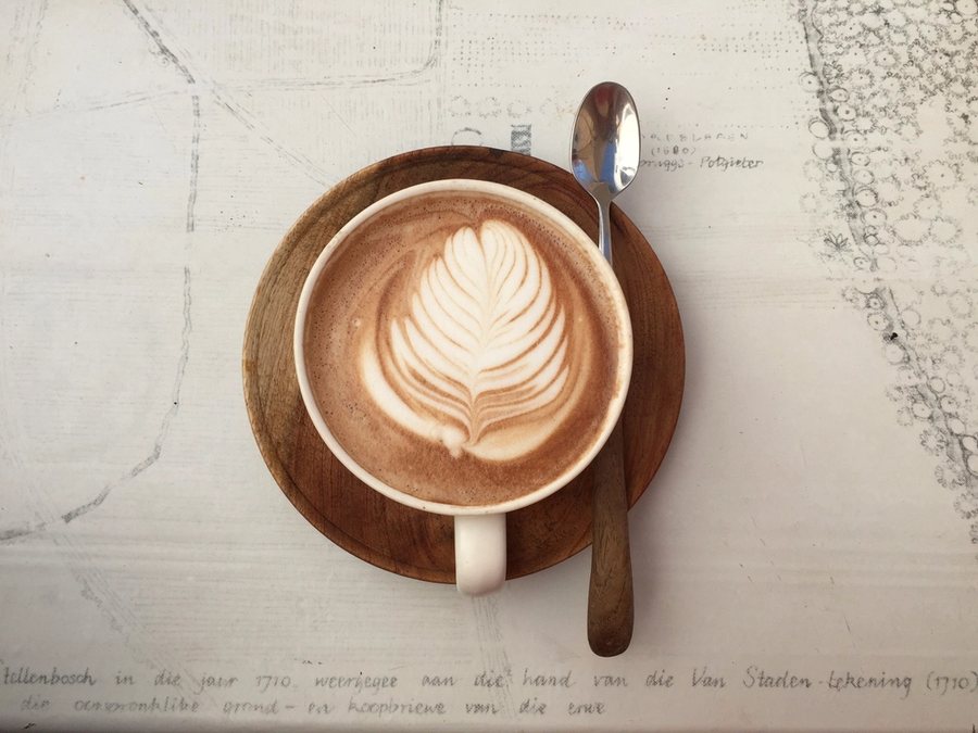 Une tasse de moka vue d’en haut, une feuille dessinée dans la mousse