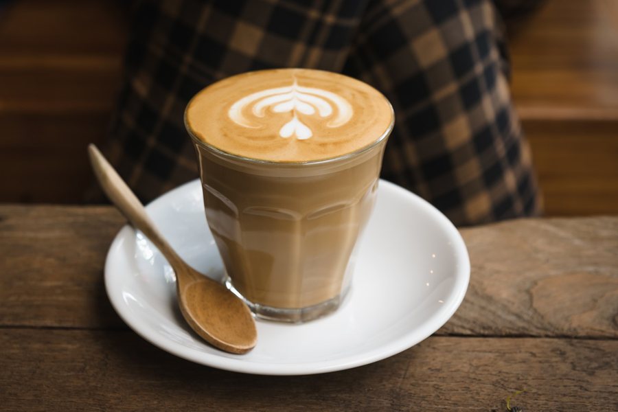 Un flat white dans un verre, un cœur dessiné dans la mousse