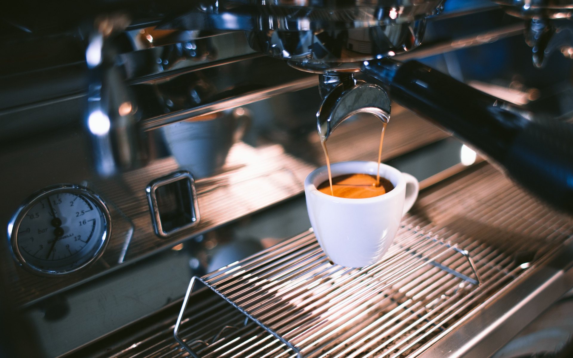 Un espresso coule de la machine dans une tasse blanche